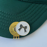 Bow golf ball marker with hat clip on green hat