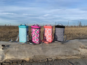 Four colorful coolers on a wooden surface with a natural background
