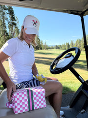 Pink and white check golf pouch in a golf cart with female golfer