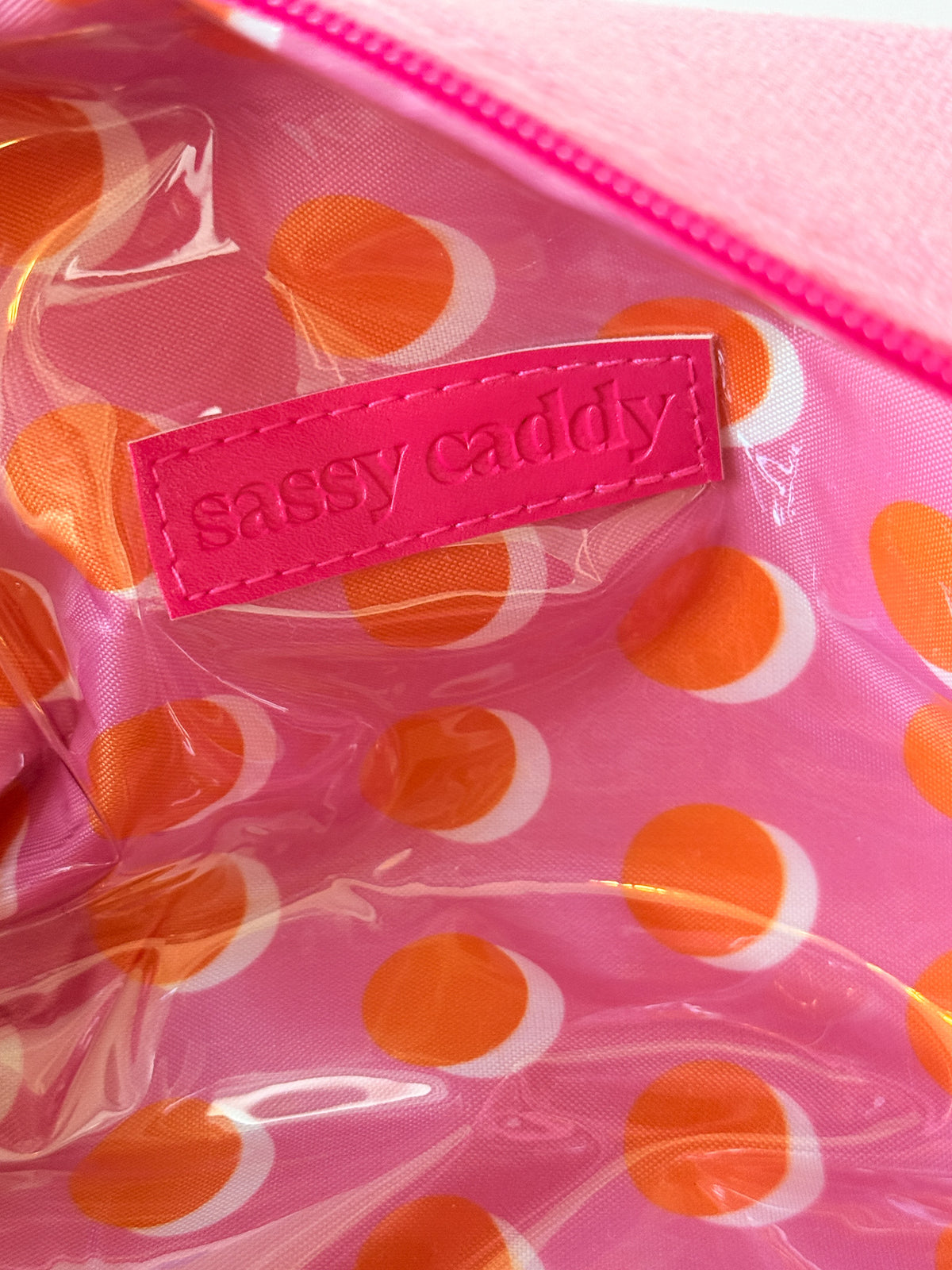 Inside of the pink golf pouch showing the orange and white polka-dot lining