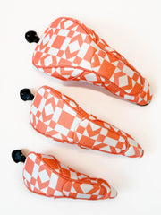 Three orange and white checkered headcovers on a white background