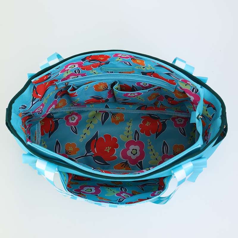 Floral-patterned bag with blue trim on a light gray background